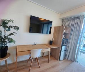 凯恩斯Studio room in Cairns Esplanade! Ocean view! Heart of Cairns的桌子在一间有盆栽的房间里