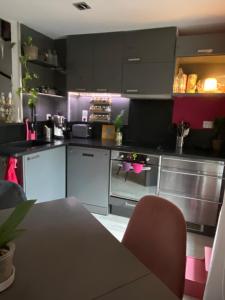 una cucina con mobili bianchi e neri e un tavolo di Pinky House a Peynier Altre 4 foto