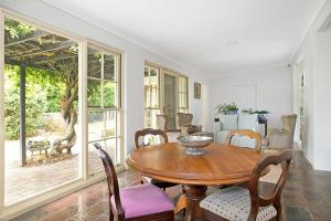 a dining room with a wooden table and chairs at Merri Cottage in Bowral
