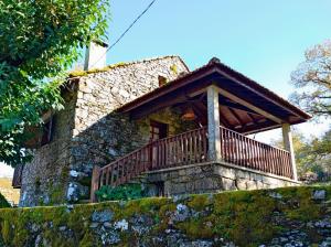 a stone house with a balcony on top of a wall at Casa do Rio, Natureza - Nova Gestão in Melgaço