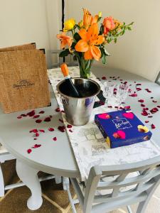 a table with a vase of flowers and a book at The Old Coach House at Stewton in Louth