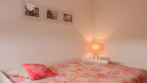 Un dormitorio con una cama y una lámpara y cuadros en la pared. en Populo Beach Apartment, en São Roque 16 fotos más