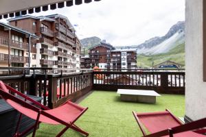 a balcony with two chairs and a table on a balcony at Appartement Ski aux Pieds 2100m - Le Nid Tignes Val Claret in Tignes
