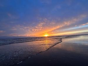 a sunset on a beach with the ocean at The Old Coach House at Stewton in Louth