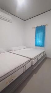 タンジュン・レスンにあるVilla Blue Ocean Tanjung Lesungの白い部屋のベッド2台 青いカーテン付 +26枚の写真