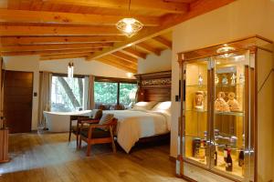 a bedroom with a bed and a bathtub and a bedroom with a tuburrency at Hotel Boutique La Casa Del Lago in Tzintzuntzán