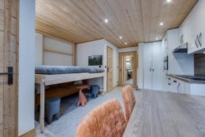 a bedroom with a bunk bed and a kitchen at Appartement Ski aux Pieds 2100m - Le Nid Tignes Val Claret in Tignes +3 photos