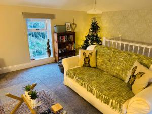 a living room with a couch and a christmas tree at The Old Coach House at Stewton in Louth