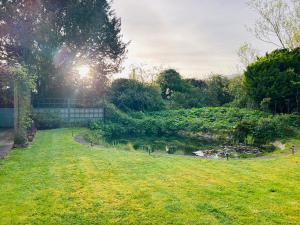 a garden with a pond in the middle of a yard at The Old Coach House at Stewton in Louth