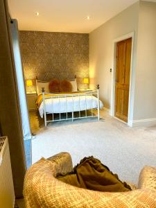 a bedroom with a bed and a couch in a room at The Old Coach House at Stewton in Louth