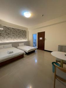 a hotel room with two beds and a table at 依藍2館 in Jincheng +34 photos
