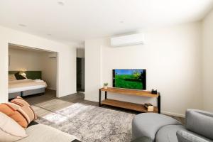 a living room with a couch and a tv at Rocky Valley Luxury Apartments in Mount Beauty