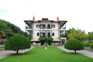 a large white house with trees in front of it at Elia Apartments Sithonia in Elia