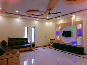 a living room with a couch and a tv at Dattatray Hollydays 3bhk with balcony isolated in Mahabaleshwar