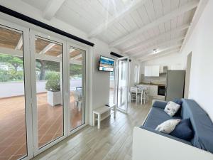 a living room with a blue couch and a kitchen at Cavoli Beach - ArgonautiVacanze in Marina di Campo