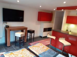 sala de estar con mesa y cocina con armarios rojos en Beale, en Todtmoos