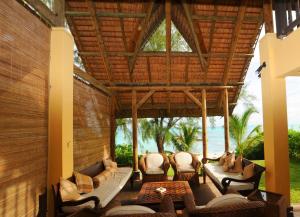 an outdoor patio with couches and tables and chairs at Ernestville 2 beachfront Villa Pointe aux Canonniers in Pointe aux Cannoniers
