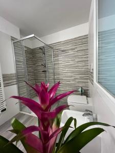 a bathroom with a large purple plant next to a toilet at B&B da Mimì in San Vito al Tagliamento
