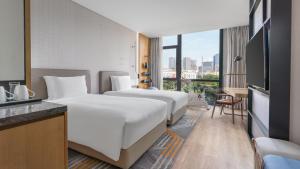 two beds in a hotel room with a view at EVEN Hotel Shenzhen Nanshan by IHG in Shenzhen +109 photos