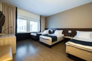 a hotel room with two beds and a window at Hotel Oscar in Varkaus +36 photos
