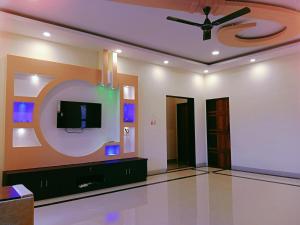 a living room with a tv and a ceiling fan at Dattatray Hollydays 3bhk with balcony isolated in Mahabaleshwar +29 photos
