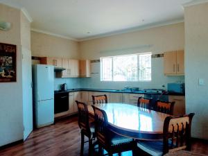 a kitchen with a table and chairs and a refrigerator at Matalatala Wildlife Lodge in Roodeplaat