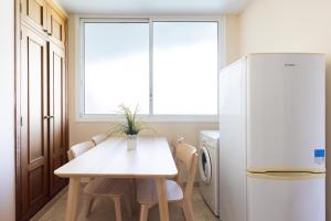 eine Küche mit einem weißen Tisch und einem Kühlschrank in der Unterkunft El Estanque - Vivienda vacacional in Puerto de la Cruz