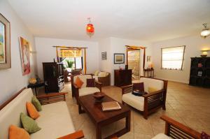 a living room with couches and a table at Ernestville 2 beachfront Villa Pointe aux Canonniers in Pointe aux Cannoniers