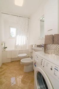 a bathroom with a toilet and a washer and dryer at Apartment Ivan in Nečujam +42 photos