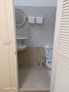 a bathroom with a toilet and a sink and a mirror at Kanyakorn House Near Khao San in Bangkok