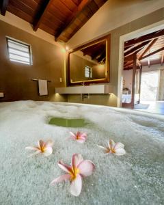 Tres flores en la arena en un baño en Lakaz Kannell - Cinnamon Room- Luxury Bedroom and Bathroom infinity pool, en Cap Malheureux