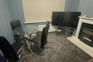 comedor con mesa de cristal y chimenea en House of Peace & Rest, en Mánchester