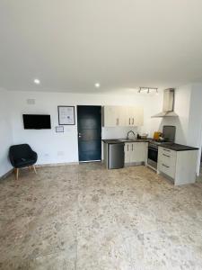 a large kitchen with white cabinets and a black appliance at RenBeck lets 2 in Urcal +11 photos