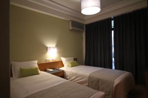 a hotel room with two beds and a window at Imperador Hotel in Lisbon +76 photos