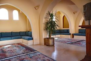 a living room with blue couches and a potted plant at Malkata House - Boutique hotel and restaurant in Luxor