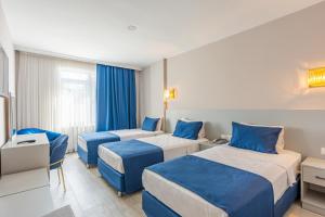 a hotel room with three beds and a couch at Safari Otel in Antalya +48 photos