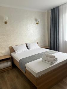 una camera da letto con un letto con due asciugamani sopra di Grand ARIA Hotel a Almaty