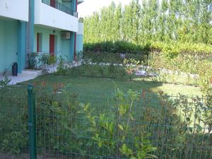 a garden in front of a house with a fence at Residence Roberta in Caorle