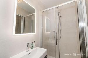a white bathroom with a shower and a sink at Seaview Retreat by Grandeur Property in Southbourne +35 photos