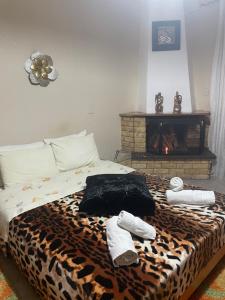 a bedroom with a leopard print bed with socks and a fireplace at Voras Apartments in Kato Loutraki