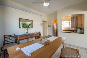 a living room with a wooden table and a desk at Coastal Nest in Durban North