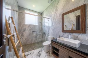 a bathroom with a sink and a toilet and a mirror at Adara Lake View Residence Bedugul - Bali in Bedugul +27 photos