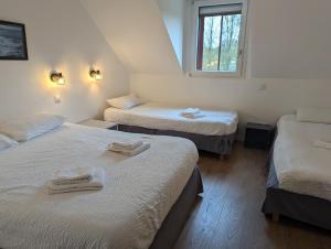 Rúm í herbergi á Logis Hôtel Lucotel