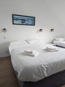 Rúm í herbergi á Logis Hôtel Lucotel