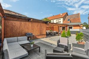 a patio with a couch and chairs and a grill at Bergblick - Wasserlage - Parkplatz - Harzduft in Thale