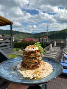 a person holding a plate with a dessert on it at Villa Blanc in Bukovel