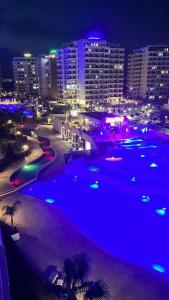 a large swimming pool with a city at night at Caesars Resort - Commodus Studio Flat in Trikomo +5 photos