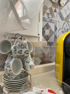 a kitchen counter with a stack of plates and cups at MareSol in Marsala