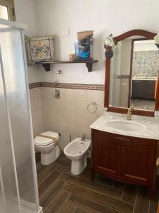 a bathroom with a sink and a toilet and a mirror at MareSol in Marsala