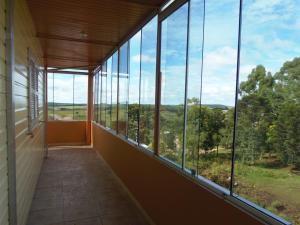 Una habitación con grandes ventanales con vistas. en Pousada Campanário, en Cambará